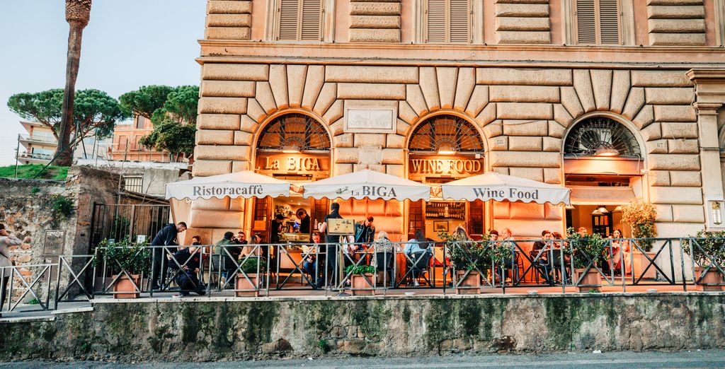 Terrasse de restaurant sous auvents oranges dans une rue romaine