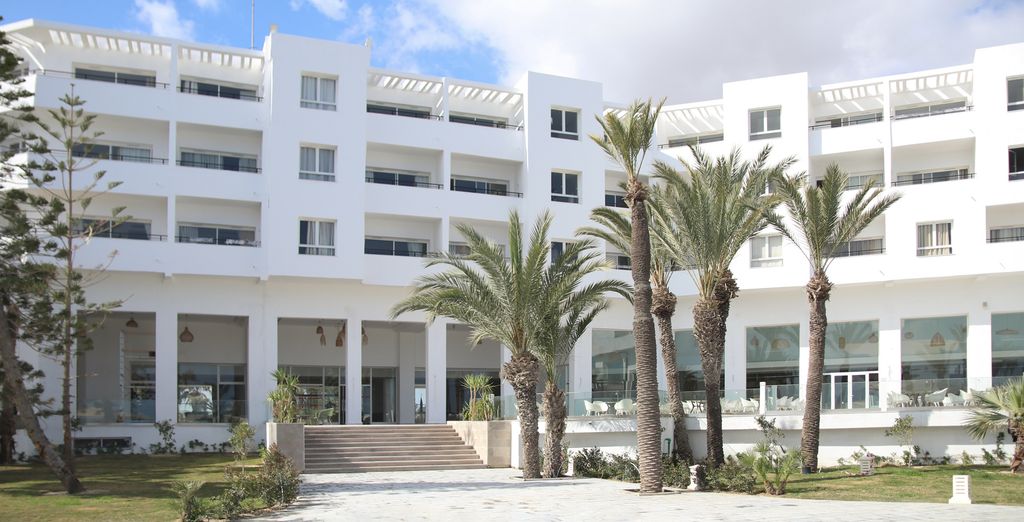 Façade blanche et palmiers du Blue Beach Club & Spa, à Skanès