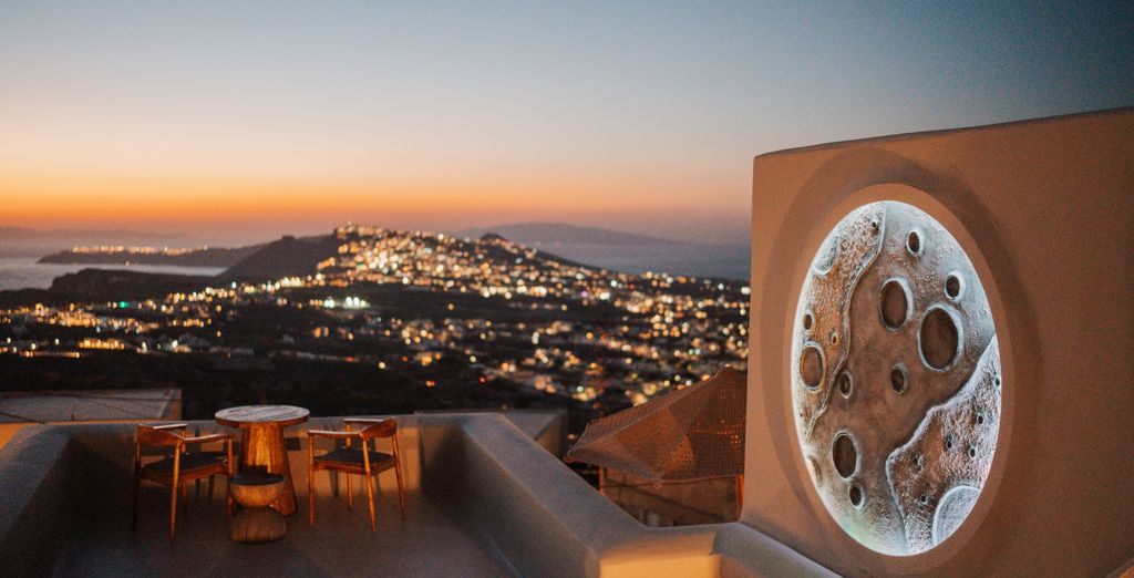 Luna Santorini Suites, terrasse au crépuscule face au village illuminé de Pyrgos